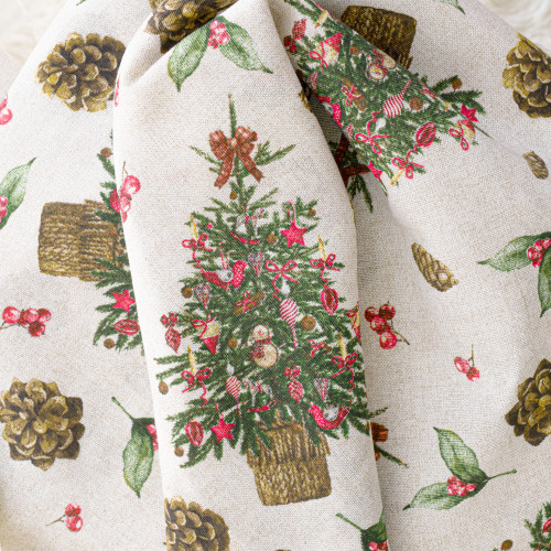 Zbliżenie na świąteczną tkaninę dekoracyjną w naturalnym kolorze ze wzorem w zielone stroiki, brązowe szyszki i czerwone akcenty.