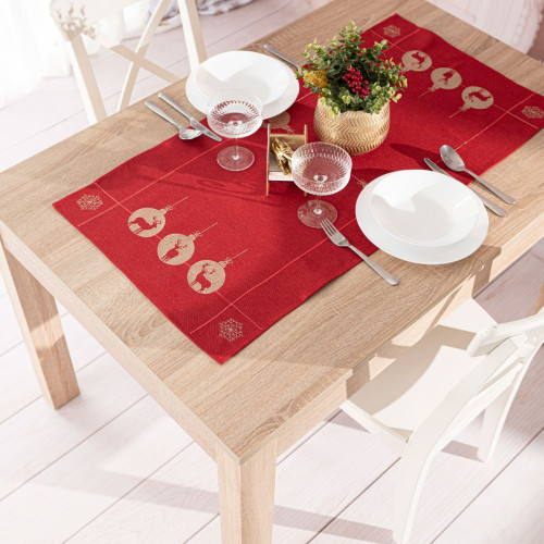 Czerwony bieżnik świąteczny z haftem złotych reniferów i bombek na drewnianym stole – dekoracja na Boże Narodzenie