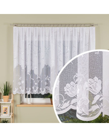Biała firanka żakardowa z kwiatowym wzorem i laserowo wykończonym dołem, zawieszona w oknie, z przybliżeniem na detal materiału.