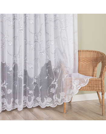 Długa firanka żakardowa (230 lub 250 cm) w białe kwiaty, z przybliżeniem na misterny wzór i laserowo wykończoną, falistą krawędzią na dole.