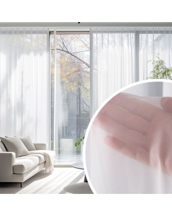 Długa, śnieżnobiała firana z woalu, delikatnie udrapowana i zawieszona w jasnym salonie ze zbliżeniem na strukturę firanki.