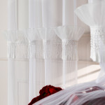 Firana do salonu na przelotkach Egret z ozdobnym pasem z frędzelkami gipiura 140x250 cm 